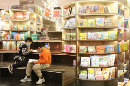 (miniature) Deux garçons lisent dans une librairie lors des vacances de la fête nationale en cours à Handan