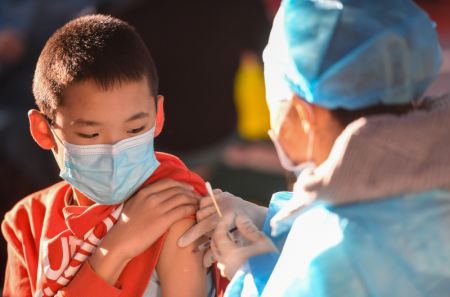 (miniature) Un garçon reçoit une dose de vaccin de COVID-19 dans une école à Hohhot