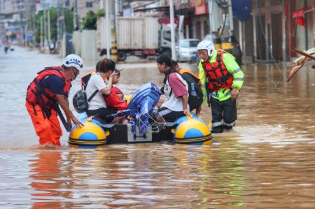 (miniature) Les membres d'une équipe civile de secours transportent des gens bloqués par les inondations avec un canot pneumatique à Quanzhou