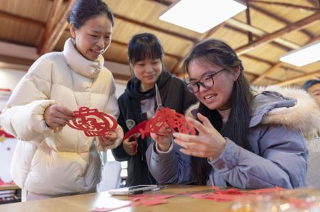 (miniature) Des gens réalisent ensemble des décorations en papier découpé à Lushan