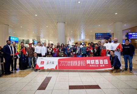 (miniature) Des touristes chinois posent pour une photo avec des membres du personnel local à l'aéroport international de Dubaï