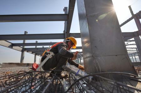 (miniature) Un travailleur sur le site de construction d'une base de maintenance de moteurs d'avions à Haikou