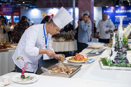 (miniature) Un chef cuisinier prépare des plats lors d'un festival gastronomique à Harbin