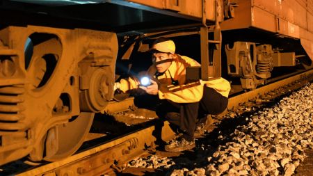 (miniature) Un ouvrier effectue des vérifications sur un train de fret dans une gare ferroviaire à Liuzhou