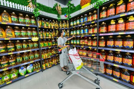 (miniature) Une femme achète de l'huile de cuisson dans un supermarché à Qingzhou