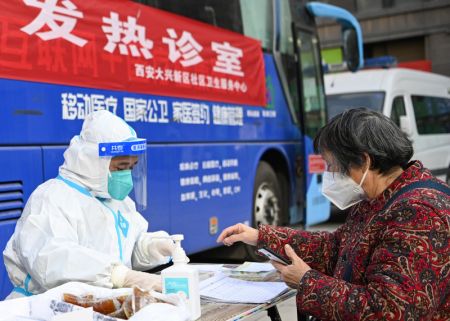 (miniature) Une femme consulte un professionnel de santé dans une clinique de traitement de la fièvre de l'arrondissement de Lianhu