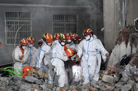 (miniature) Des secouristes transportent le dixième survivant de l'effondrement d'un bâtiment résidentiel