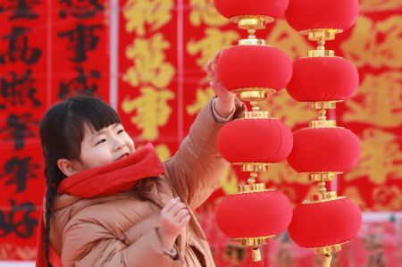 (miniature) Une jeune fille regarde des lanternes rouges sur un marché de Gaomi