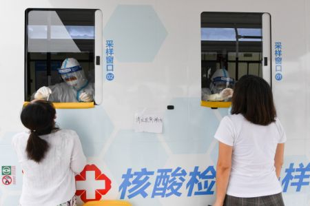 (miniature) Des professionnels de santé effectuent des prélèvements de gorge sur des habitants dans un véhicule de dépistage mobile récemment mis en service dans l'arrondissement de Xicheng
