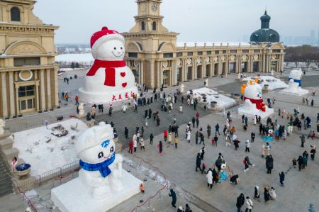 (miniature) Vue aérienne de gens visitant un bonhomme de neige géant