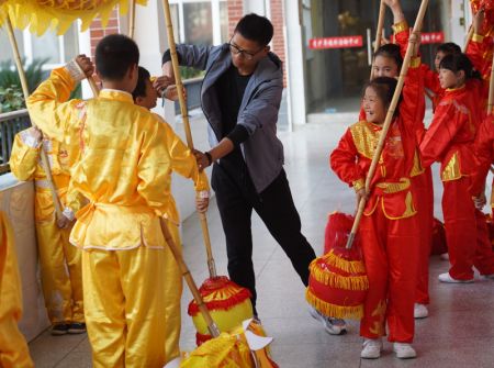 (miniature) L'entraîneur Yan Wenlong enseigne à ses élèves la danse traditionnelle du dragon à l'école primaire N° 2 de Jing'an