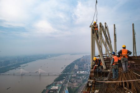 (miniature) Des ouvriers travaillent à une hauteur d'environ 500 mètres sur le chantier d'un gratte-ciel à Wuhan