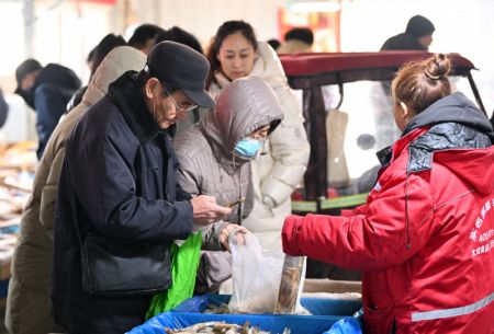(miniature) Des personnes sélectionnent des crevettes lors d'une foire en préparation de la fête du Printemps à venir