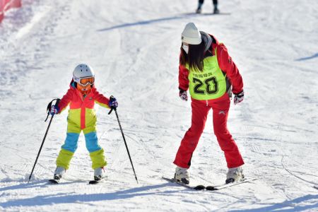 (miniature) Une monitrice apprend à un enfant à faire du ski dans une station de sports d'hiver à Shijiazhuang