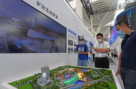 (miniature) Des visiteurs regardent des maquettes de restauration écologique lors de la Conférence sur la science du bâtiment et l'Exposition du bâtiment intelligent et écologique de Chine