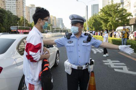 (miniature) Un policier guide un véhicule transportant un candidat à un site d'examen à Beijing