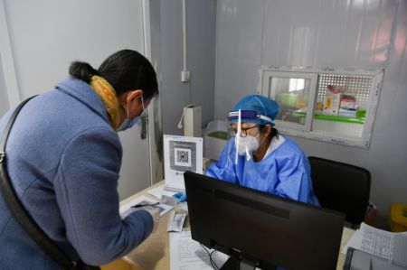 (miniature) Une femme consulte une professionnelle de santé dans une clinique de traitement de la fièvre de l'arrondissement de Beilin