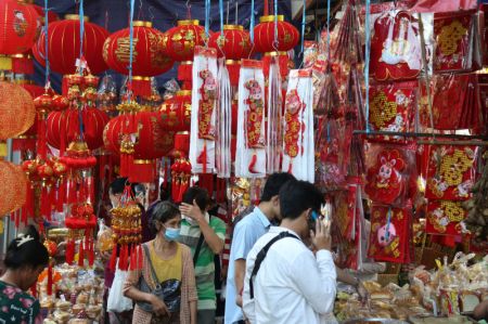 (miniature) Des personnes achètent des articles de décoration pour le Nouvel An lunaire chinois au Chinatown de Yangon au Myanmar