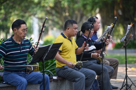 (miniature) Des gens jouent d'instruments traditionnels chinois au parc Evergreen de Haikou