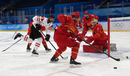 (miniature) Le gardien chinois Yongli Ouban (1er à droite) effectue un arrêt pendant le match de phase de poule du groupe A de hockey sur glace hommes entre la Chine et le Canada