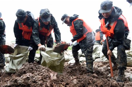 (miniature) Des policiers armés remplissent des sacs de sable sur la digue de la rivière Shiba