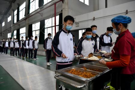 (miniature) Des élèves du Collège des langues étrangères de Xi'an font la queue pour déjeuner dans le gymnase aménagé en cantine