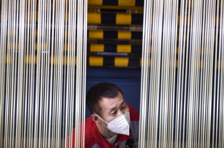(miniature) Un employé vérifie des filaments bruts dans la base de production de la société Zhongfu Shenying Carbon Fiber Co