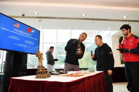 (miniature) Des membres du personnel vérifient l'état des objets culturels chinois remis lors d'une cérémonie de restitution au Consulat général de Chine à New York