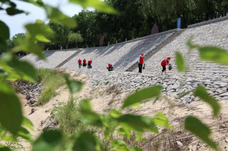 (miniature) Des bénévoles ramassent des déchets sur la rive du fleuve Jaune