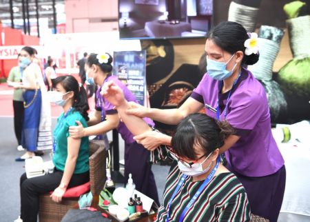 (miniature) Des visiteurs font l'expérience d'un massage de style thaïlandais dans le pavillon de la Thaïlande lors de la 18e Exposition Chine-ASEAN à Nanning