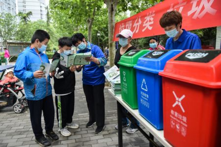 (miniature) Deux enfants apprennent les règles de tri des déchets lors d'une campagne de sensibilisation à la gestion des déchets dans une communauté résidentielle de l'arrondissement de Dongcheng à Beijing