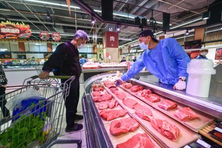 (miniature) Un habitant achète de la viande dans un supermarché de l'arrondissement de Songjiang
