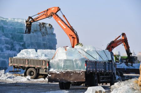(miniature) Des véhicules du génie soulèvent de la glace sur le chantier de construction du Monde de glace et de neige de Harbin