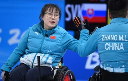 (miniature) La Chinoise Yan Zhuo (à gauche) exprime sa joie avec Zhang Mingliang lors de l'épreuve de curling en fauteuil roulant entre la Chine et la Slovaquie