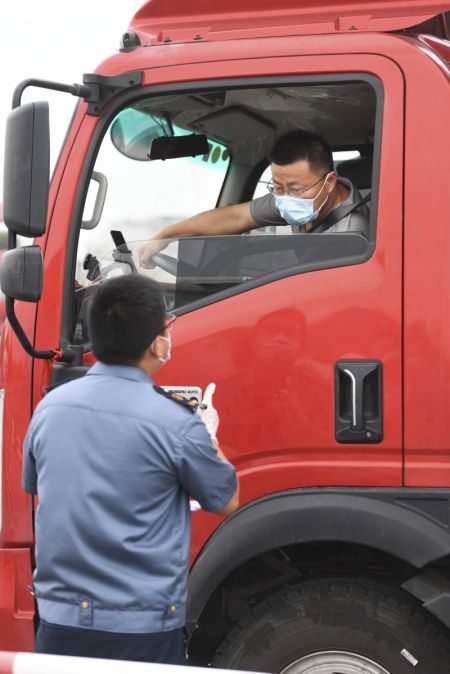 (miniature) Un employé vérifie les résultats des tests d'acide nucléique et les codes de santé au poste de péage de Caozhuang