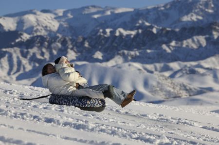 (miniature) Des touristes profitent du snowtubing près du village de Tianshan du bourg de Tiechanggou à Urumqi