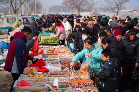 (miniature) Des gens visitent une foire locale pour le prochain Nouvel An chinois dans le district de Linyi