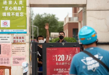 (miniature) Un habitant fait signe à un livreur à l'entrée d'un quartier de l'arrondissement de Xicheng