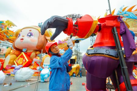 (miniature) Une employée confectionne une lanterne colorée sur le site du prochain festival des lanternes à Zigong