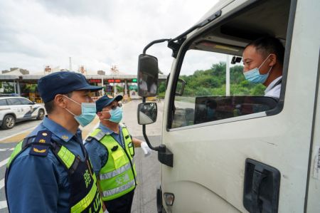 (miniature) Des employés informent un conducteur d'une annonce de prévention et de contrôle de la COVID-19 au poste de péage de Xishanqiao