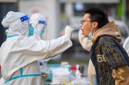 (miniature) Une membre du personnel médical prélève un échantillon de gorge sur un habitant pour un test d'acide nucléique à Hohhot