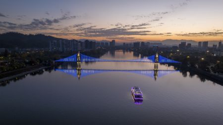 (miniature) Photo aérienne d'un pont illuminé pour célébrer la Journée mondiale de l'enfance sur la rivière Xin'an