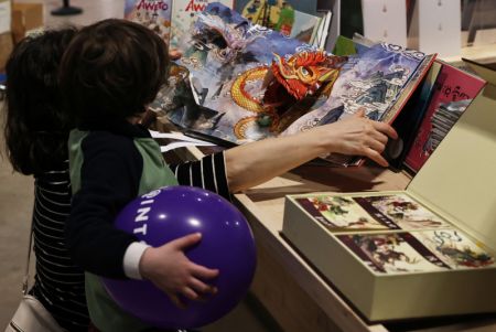 (miniature) Des visiteurs lisent des livres chinois pour enfants lors du Festival du livre de Paris 2024 à Paris