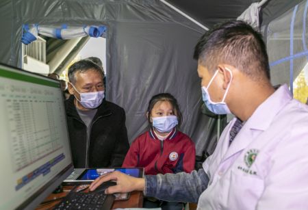 (miniature) Une jeune élève est enregistré pour se faire vacciner contre la COVID-19 dans un site de vaccination de la ville de Qianxi