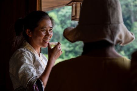 (miniature) Une villageoise (à gauche) présente son thé Pu'er fait maison à une touriste dans un village traditionnel de la montagne Jingmai