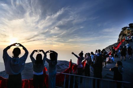 (miniature) Des visiteurs admirent le coucher de soleil au mont Huashan