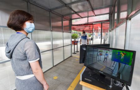 (miniature) Une employée vérifie l'équipement de contrôle de la température à l'entrée d'une école secondaire à Taiyuan