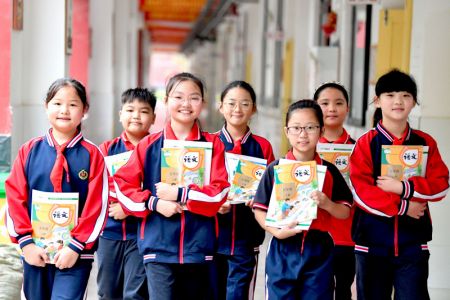 (miniature) Des écoliers montrent leurs nouveaux manuels scolaires dans une école primaire à Bozhou
