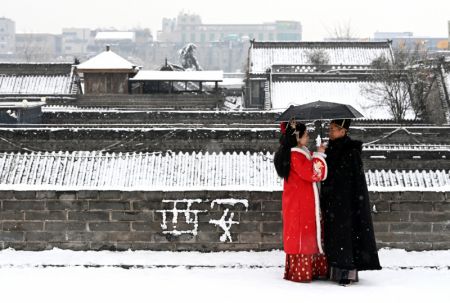 (miniature) Des touristes admirent le paysage sur les anciens remparts enneigés de Xi'an