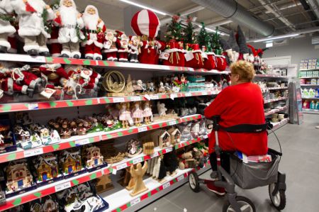 (miniature) Une cliente choisit des produits de Noël fabriqués en Chine sur un marché de Haarlem